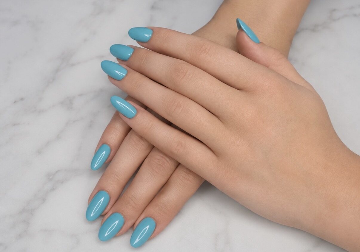 Uñas almendradas largas azul turquesa, sobre mármol gris.