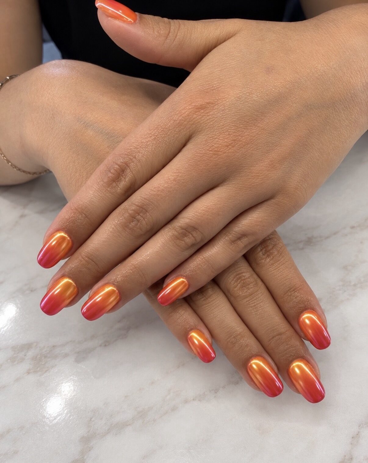 Uñas almendradas en degradado naranja coral, del más claro al más intenso.